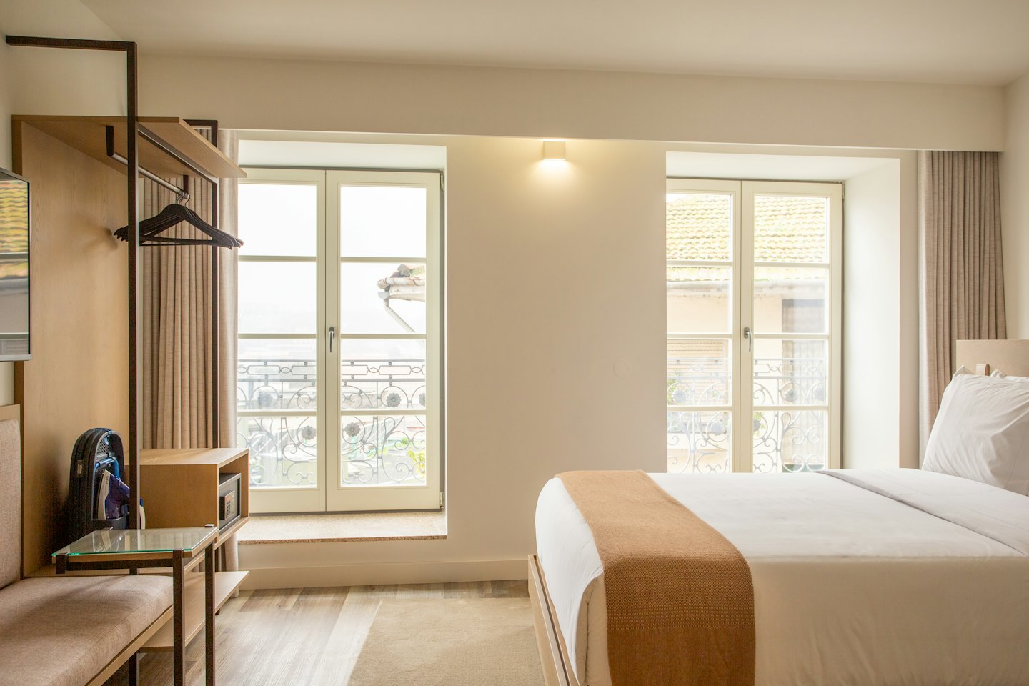 Chambre d'hôtel avec un lit fait et vue sur la ville.