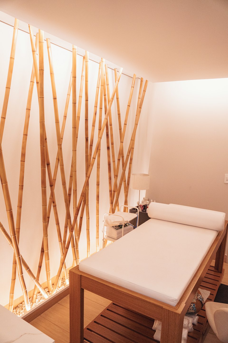 Chambre de spa vide avec mur en bambou et table de massage.