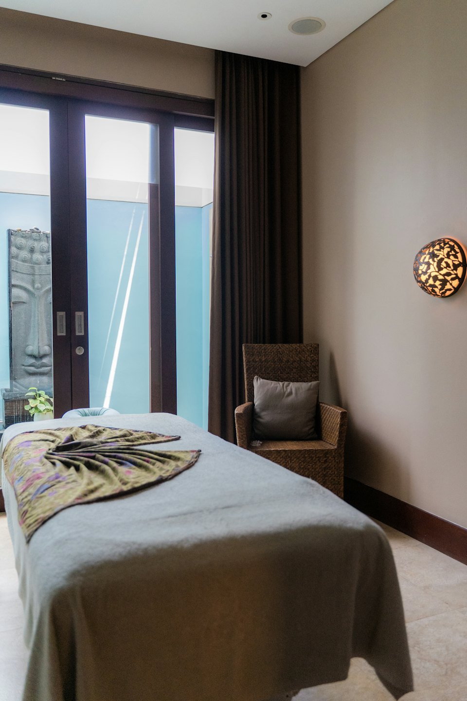 Chambre de spa vide avec table de massage et statue de Bouddha.