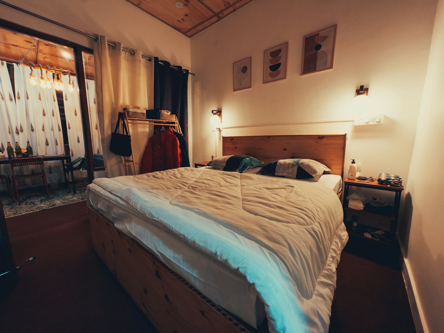 Chambre douillette avec meubles en bois et coin salon attenant.